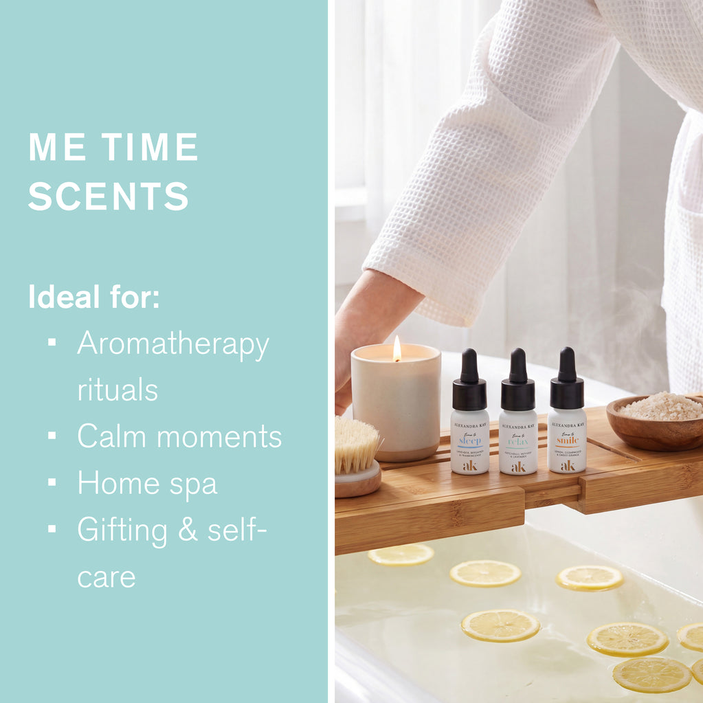 Alexandra Kay Me Time Scents en una bandeja de baño de madera junto a una vela, cepillo y baño con rodajas de limón. Ideal para aromaterapia.
