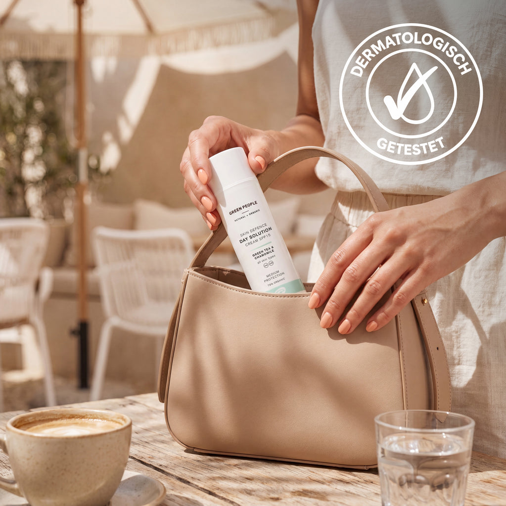 Eine Person steckt die dermatologisch getestete Green People Tagescreme LSF 15 in eine beige Handtasche.