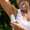 Woman applying Green People Aloe Vera & Prebiotics Deodorant, with a Dermatologically Tested badge.