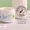 Un bote blanco abierto de bálsamo Organic Babies Mum & Baby Rescue Balm sobre una superficie de mármol junto a un sello "dermatológicamente probado".