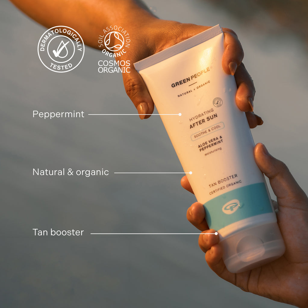 Manos sostienen tubo de crema solar Green People Hydrating After Sun, destacando ingredientes naturales y beneficios potenciadores del bronceado.
