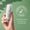 Eine Hand hält eine Flasche Green People Scent Free Gesichts- und Hals-Serum vor einem grünen Hintergrund mit einem "Dermatologisch Getestet"-Logo.