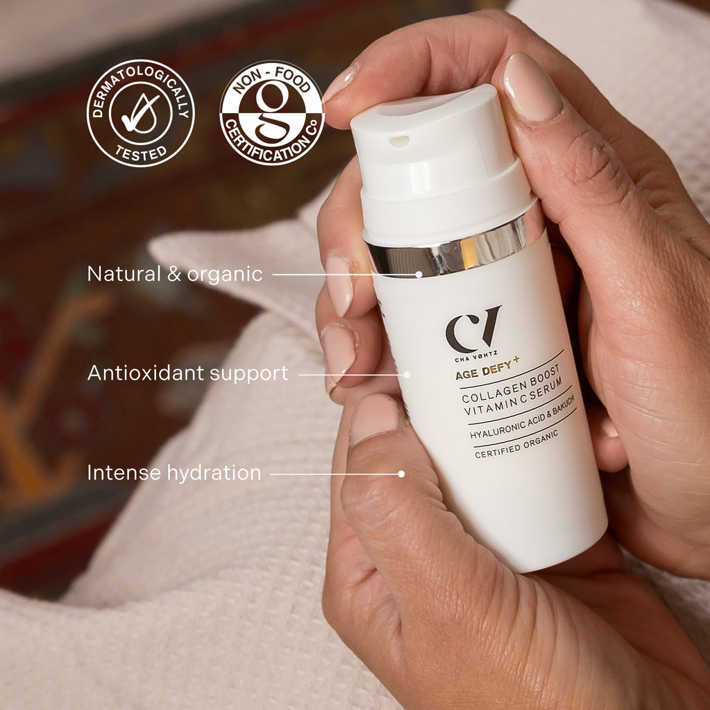 Manos sostienen el suero Age Defy+ Collagen Boost Vitamin C, destacando su fórmula natural, antioxidantes e hidratación intensa.