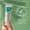 Una mano sostiene un tubo de Oy Clear Skin Purifying Serum contra un fondo verde suave con una insignia de "dermatológicamente probado".